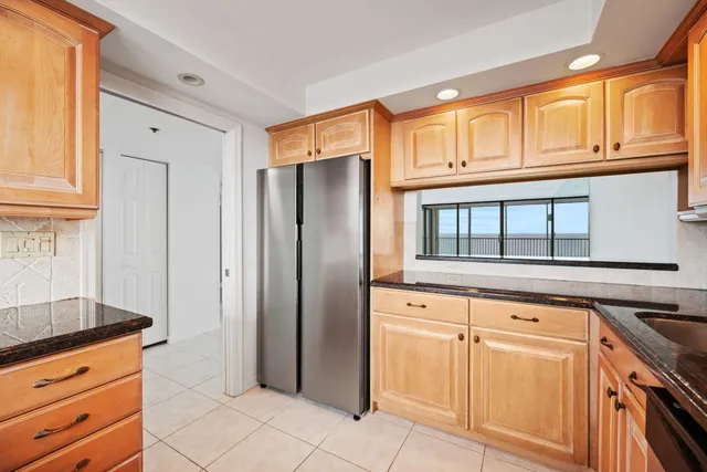 a kitchen with granite countertop a refrigerator and cabinets