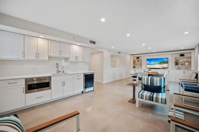 a open kitchen with stainless steel appliances kitchen island granite countertop a stove and white cabinets