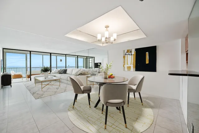 a living room with furniture a chandelier and a dining table
