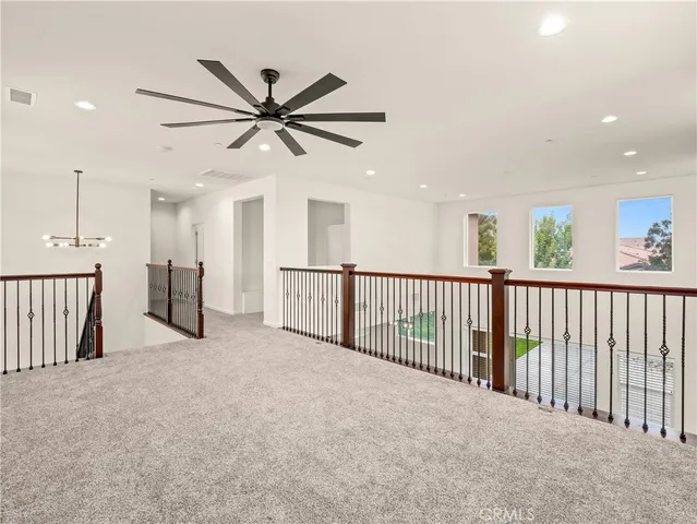 a view of a hallway with a ceiling fan