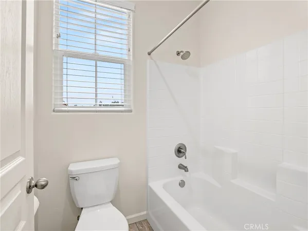 a white toilet sitting next to a bath tub