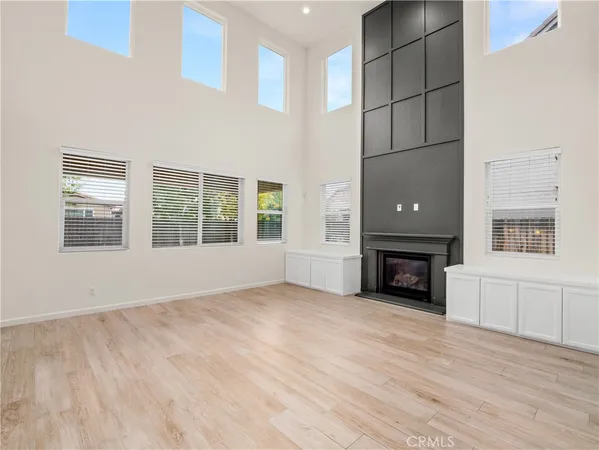 a view of an empty room with a window and fire place