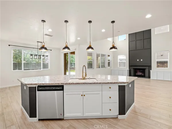 a kitchen with granite countertop a stove a sink and a wooden floors