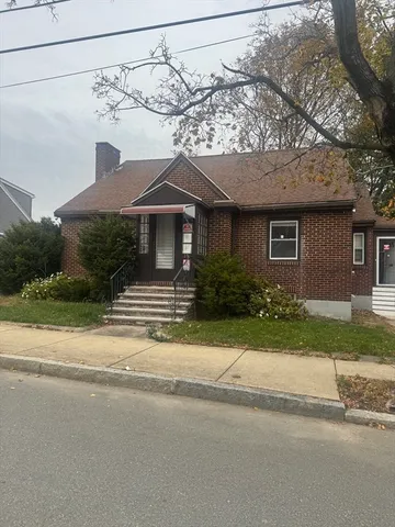 a front view of a house with a garden and plants