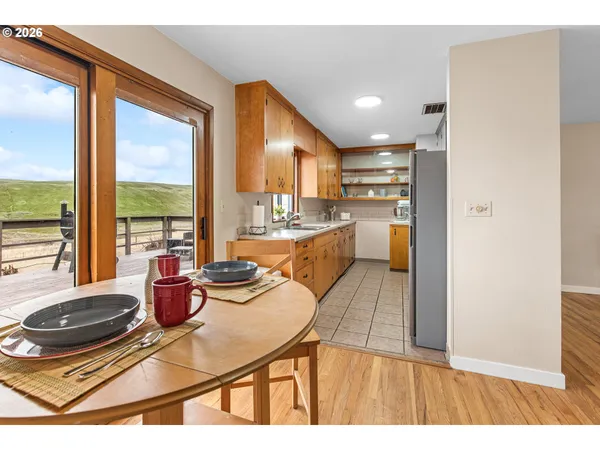 a kitchen with stainless steel appliances granite countertop a stove a sink and a dining table with wooden floor