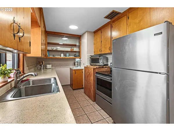 a kitchen with stainless steel appliances a refrigerator sink and cabinets