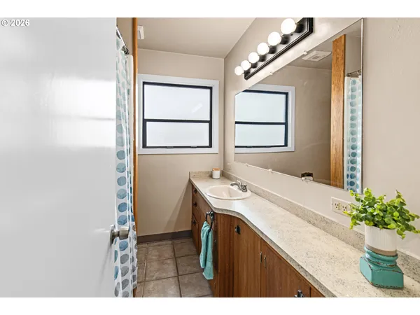a bathroom with a sink a mirror and a shower