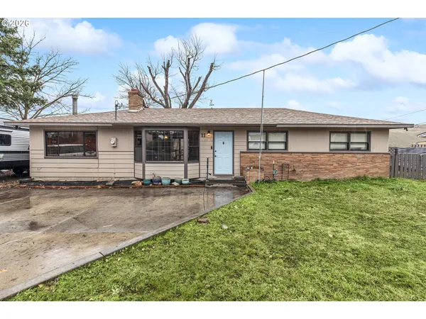 a front view of a house with a garden and yard