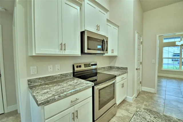 a kitchen with stainless steel appliances granite countertop a stove a microwave and a sink