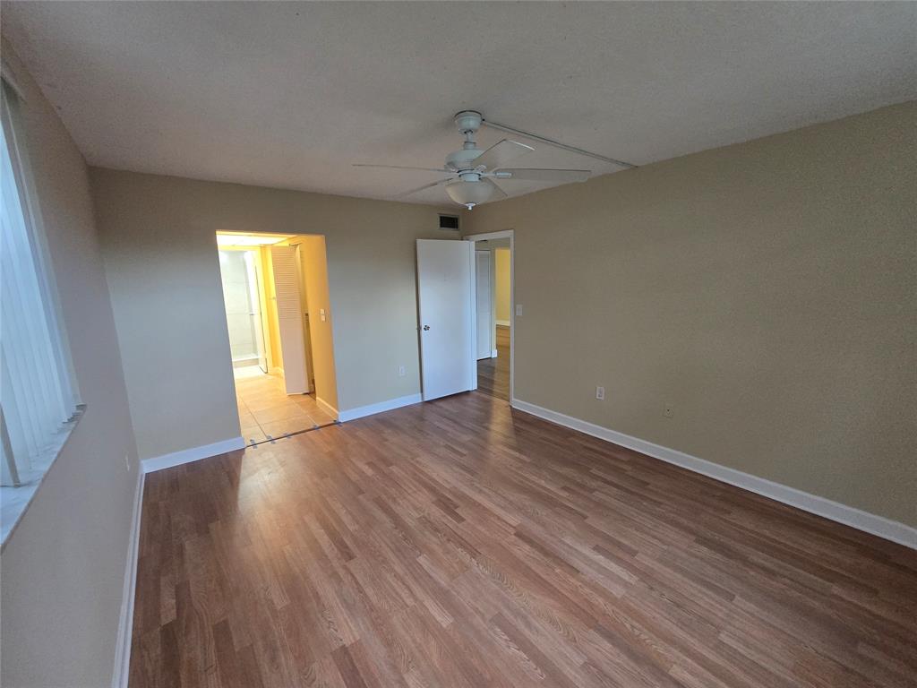 1681 Northwest 70th Avenue, Unit 403 Plantation, FL 33313 - Photo 17 of 54 a view of an empty room with wooden floor and a window