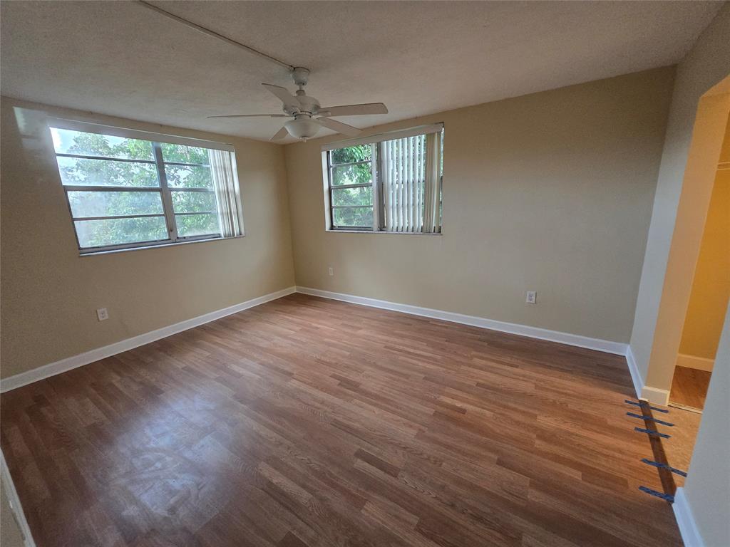 1681 Northwest 70th Avenue, Unit 403 Plantation, FL 33313 - Photo 19 of 54 a view of an empty room with wooden floor and a window