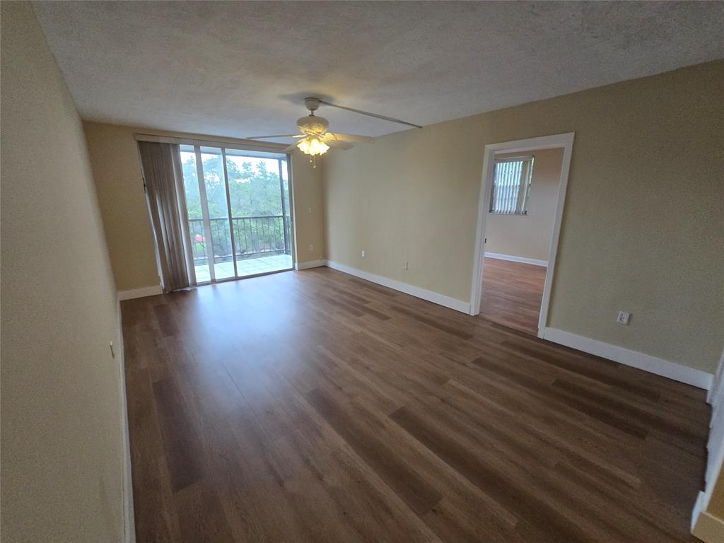 1681 Northwest 70th Avenue, Unit 403 Plantation, FL 33313 - Photo 21 of 54 a view of an empty room with wooden floor and a window
