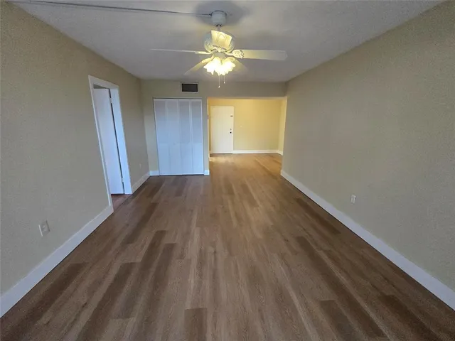 a view of an empty room with wooden floor
