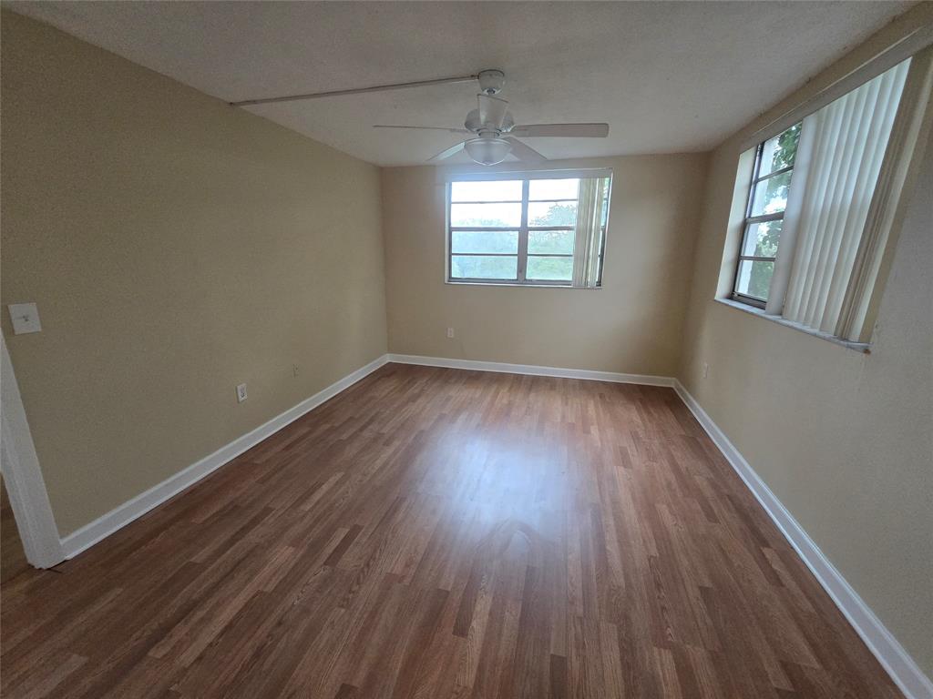 1681 Northwest 70th Avenue, Unit 403 Plantation, FL 33313 - Photo 25 of 54 a view of an empty room with wooden floor and a window