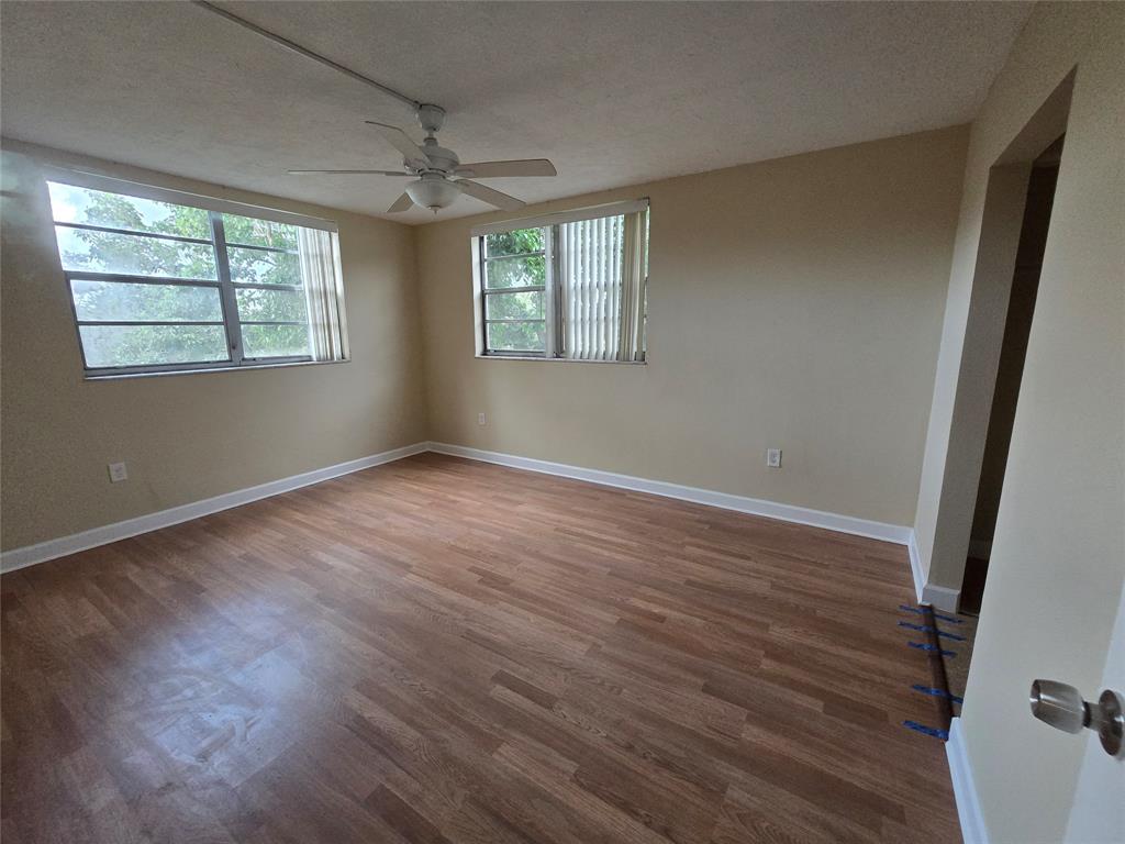 1681 Northwest 70th Avenue, Unit 403 Plantation, FL 33313 - Photo 28 of 54 a view of an empty room with wooden floor and a window