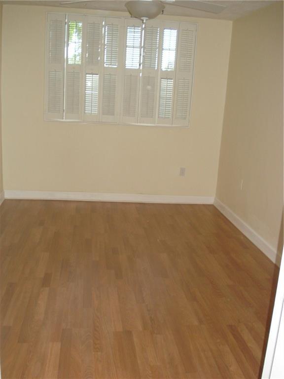 1681 Northwest 70th Avenue, Unit 403 Plantation, FL 33313 - Photo 6 of 54 an empty room with wooden floor and windows