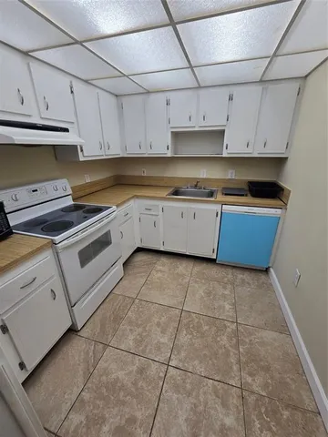 a kitchen with granite countertop white cabinets and a sink