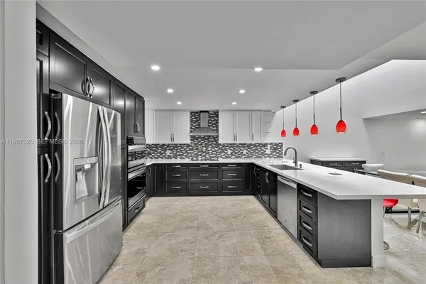 a kitchen with granite countertop a refrigerator and a sink