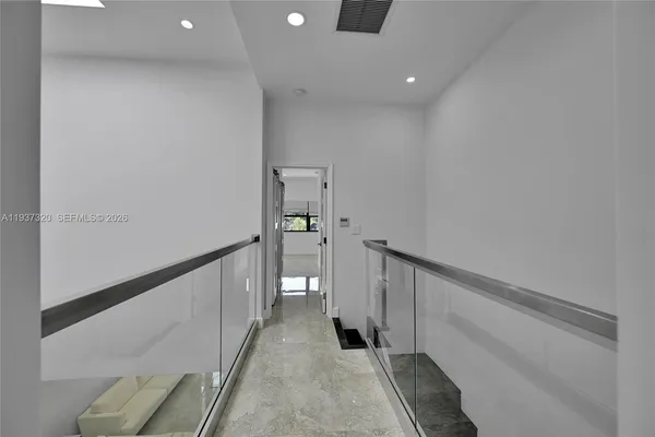 an empty room with windows and ceiling fan