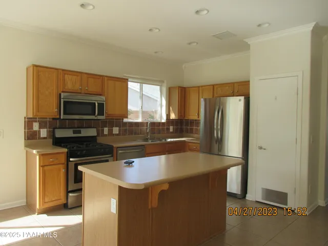 a kitchen with granite countertop a refrigerator and a stove top oven
