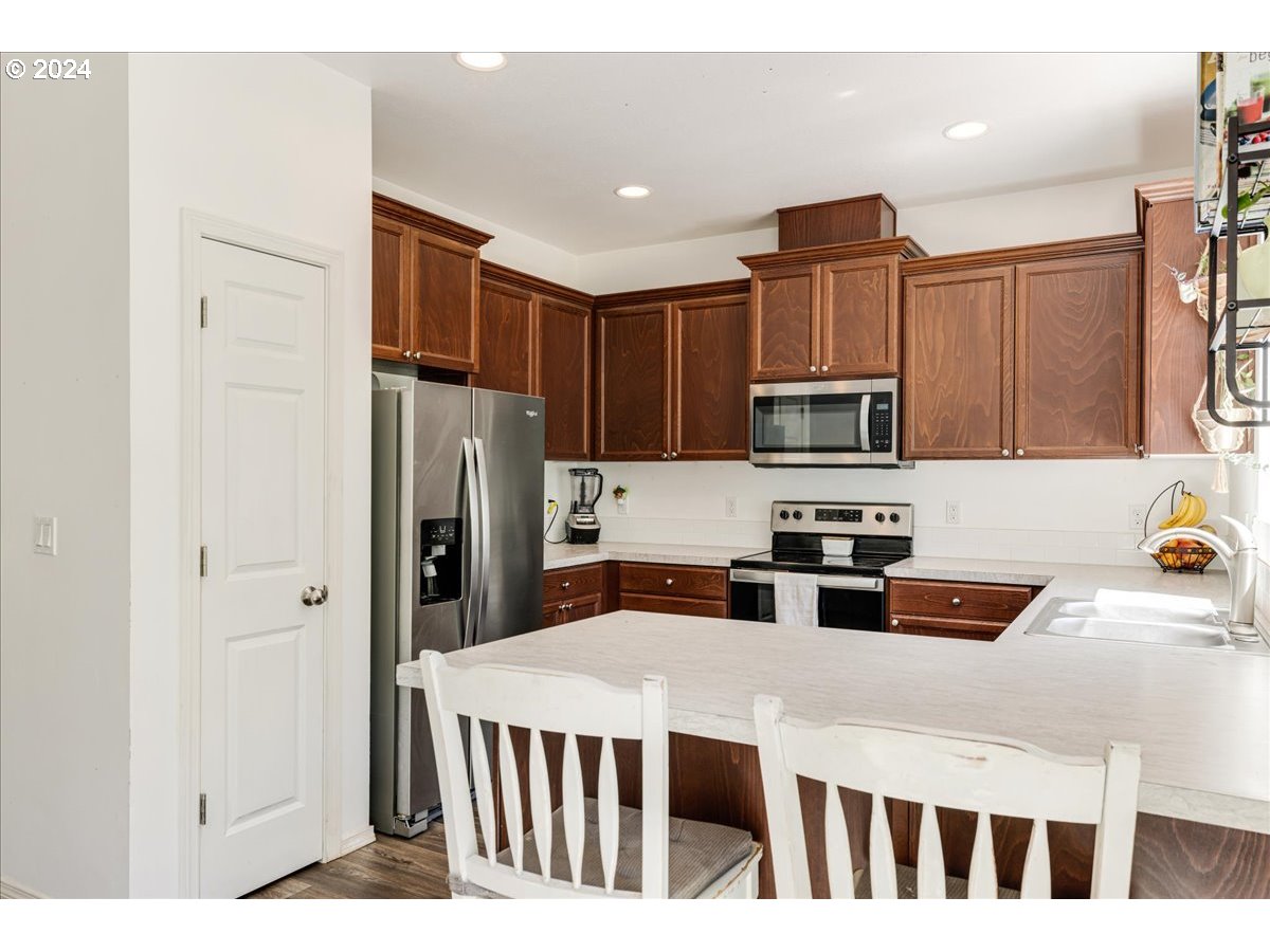 8445 King Road Grand Ronde, OR 97347 - Photo 16 of 38 a kitchen with stainless steel appliances a refrigerator sink microwave and cabinets