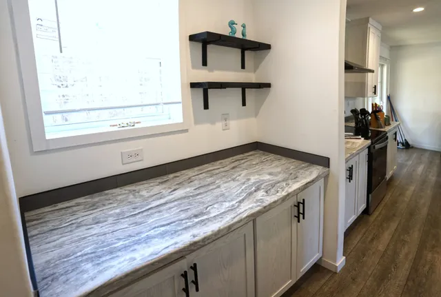 a bathroom with a granite countertop sink toilet a mirror and shower