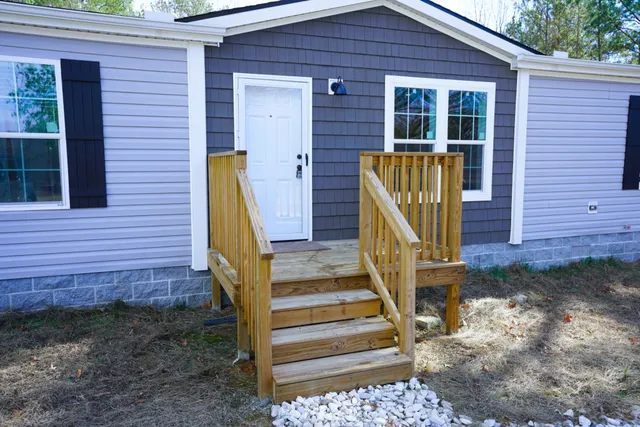 a view of a house with stairs and a yard