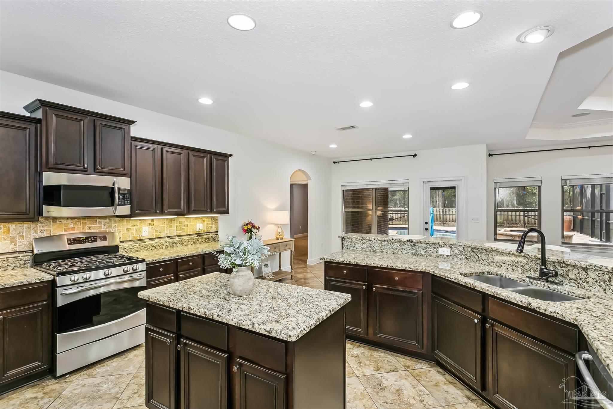 8414 Foxtail Loop Pensacola, FL 32526 - Photo 12 of 22 a kitchen with granite countertop kitchen island a sink stove and oven