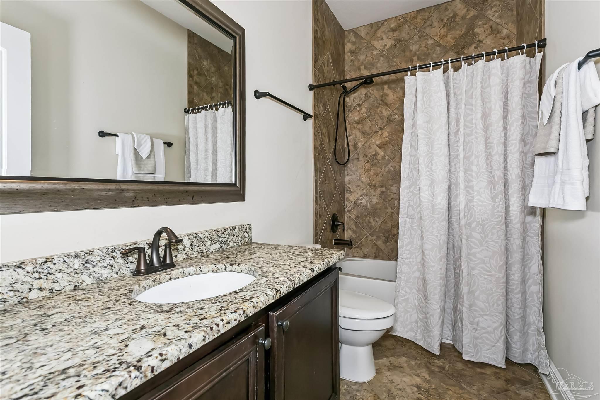 8414 Foxtail Loop Pensacola, FL 32526 - Photo 14 of 22 a bathroom with a granite countertop sink toilet and shower