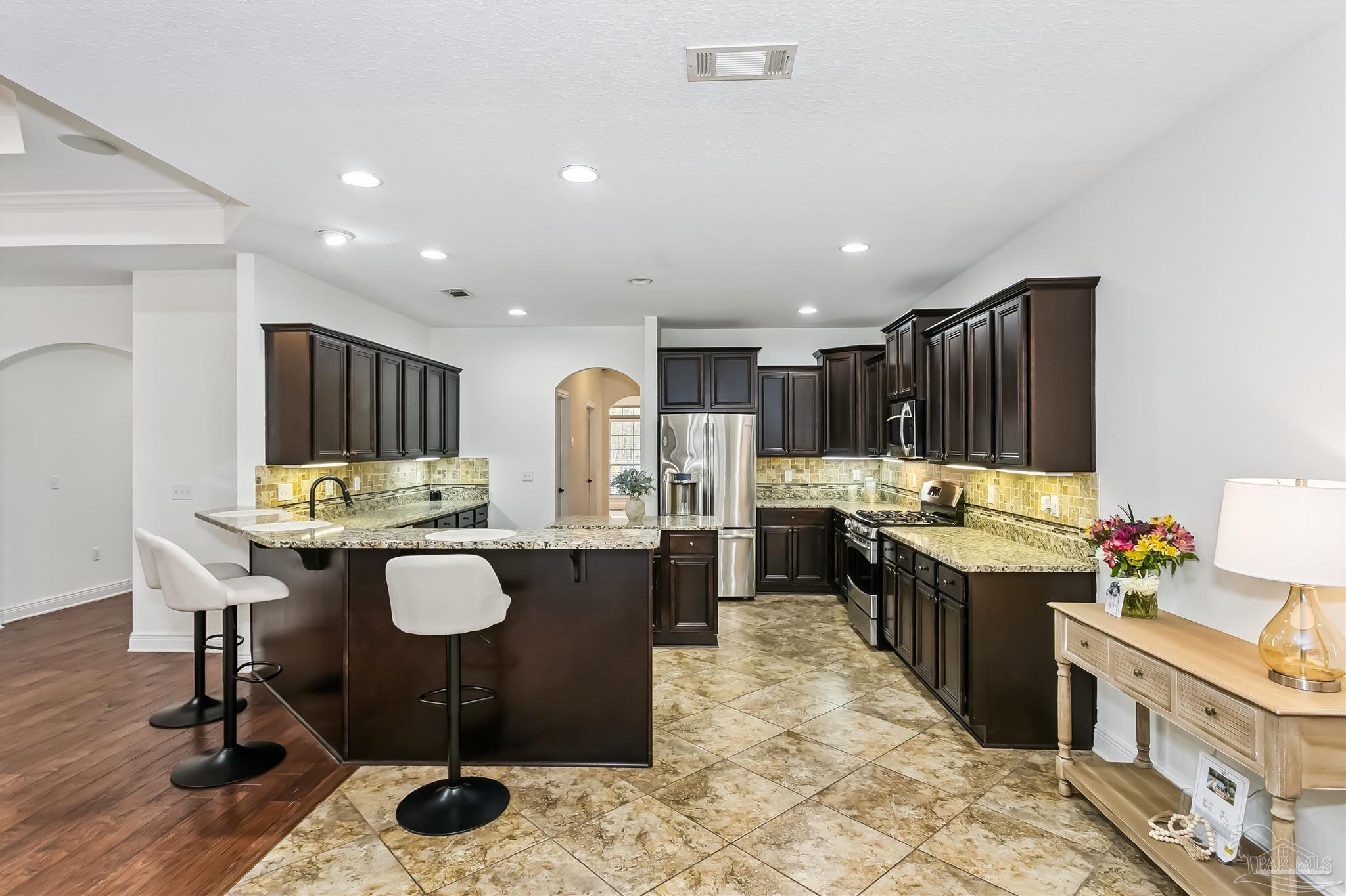 8414 Foxtail Loop Pensacola, FL 32526 - Photo 10 of 22 a kitchen with a table chairs stove and cabinets