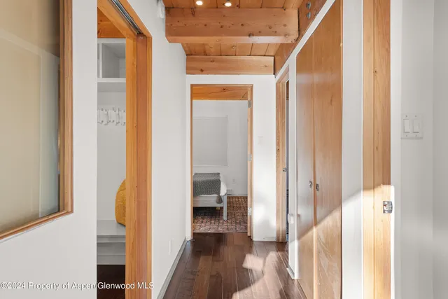 a view of a hallway with wooden floor and staircase