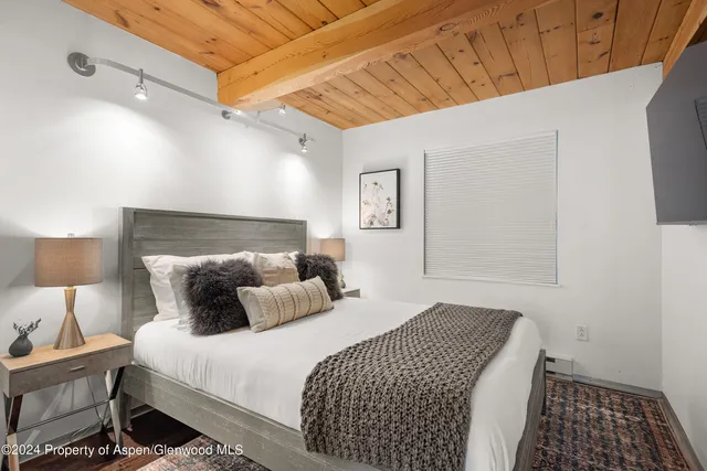 a bedroom with a bed and a lamp with the table