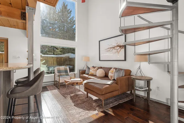 a living room with furniture a wooden floor and a large window
