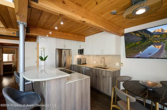 a kitchen with stainless steel appliances granite countertop a sink a stove and a refrigerator
