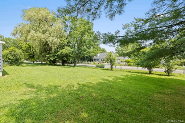a view of yard with green field and trees