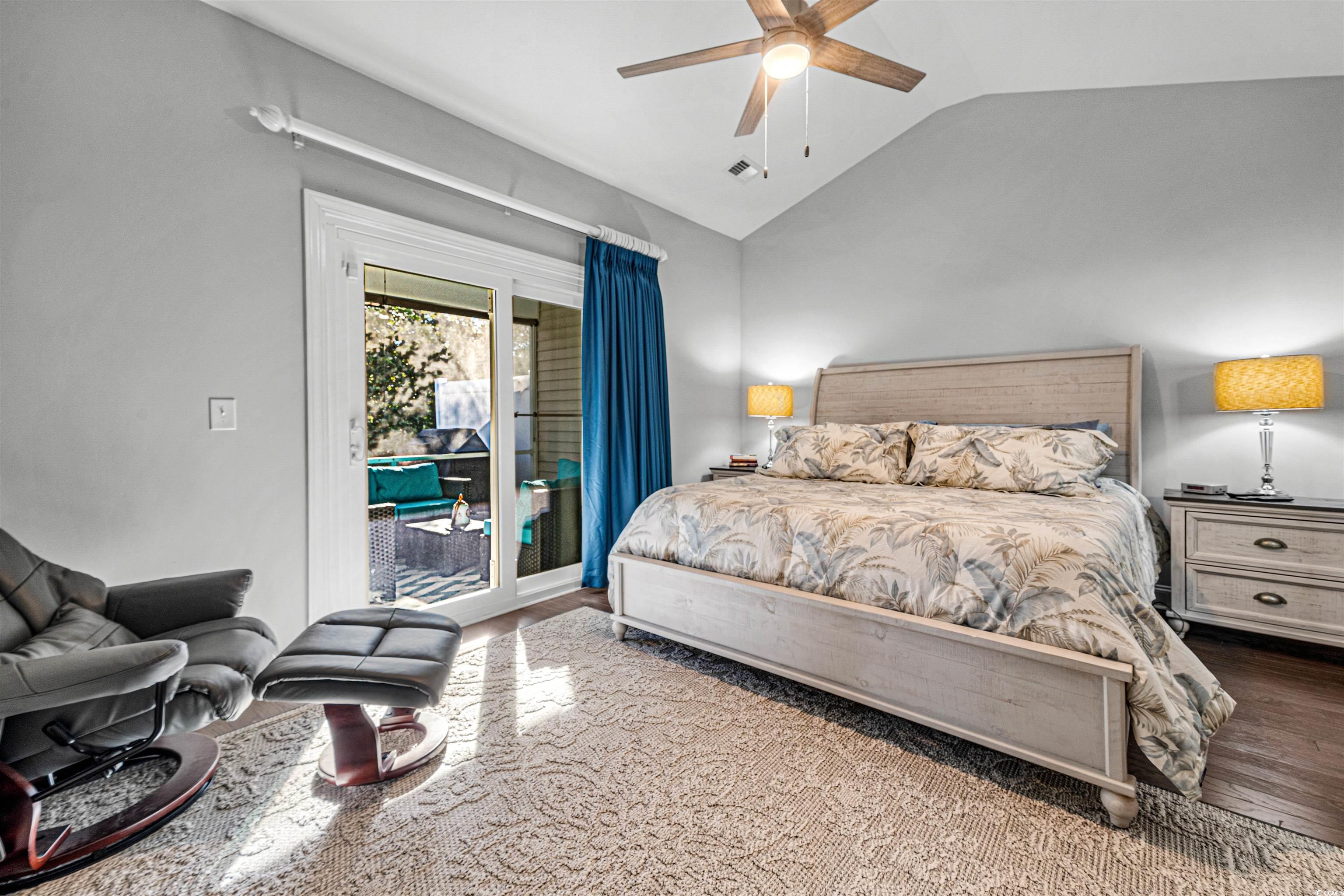 136 Parmelee Drive, Unit C Murrells Inlet, SC 29576 - Photo 20 of 40 Bedroom featuring wood finished floors, lofted ceiling, access to exterior, and a ceiling fan