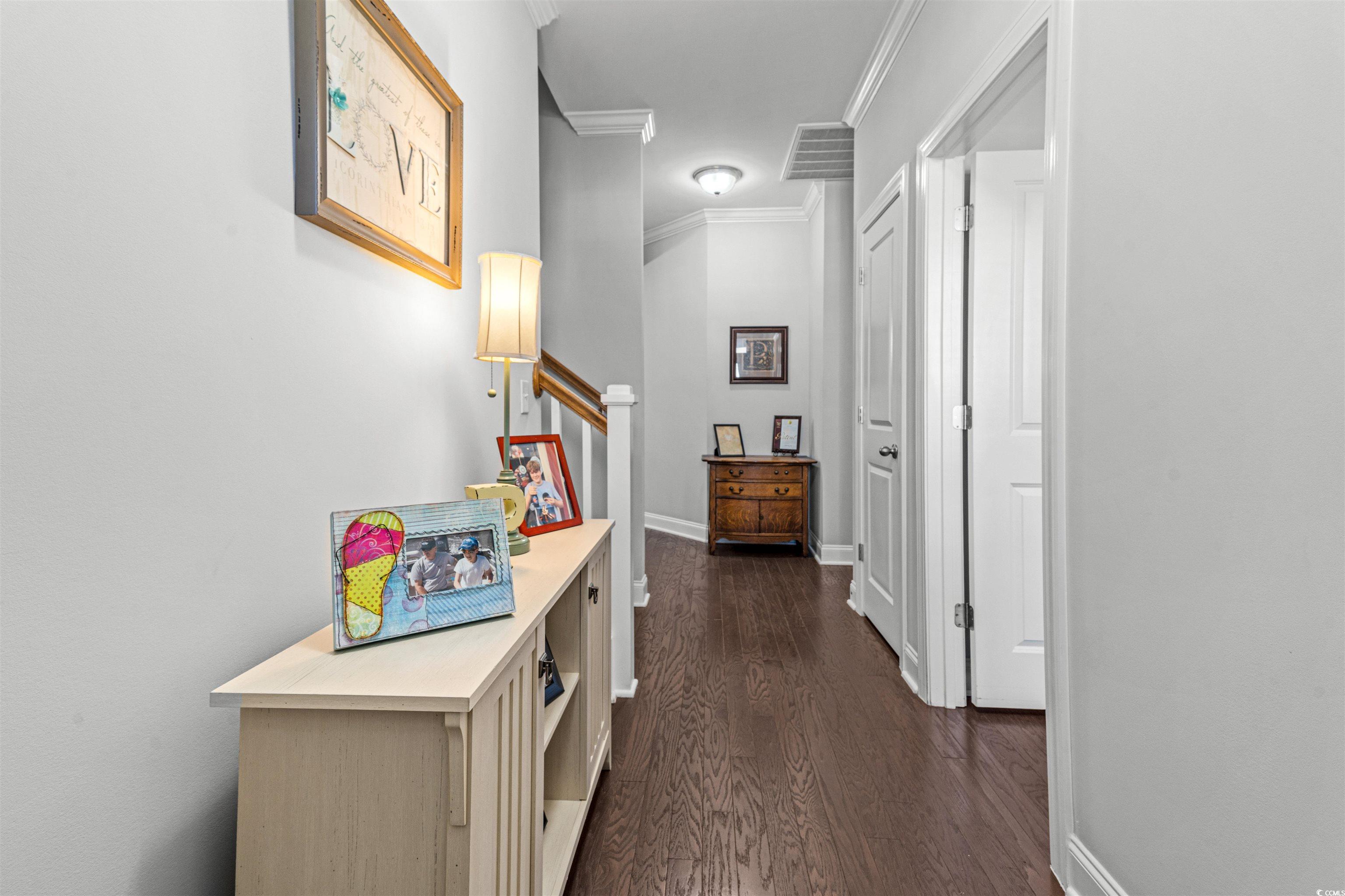 136 Parmelee Drive, Unit C Murrells Inlet, SC 29576 - Photo 2 of 40 Corridor with crown molding, dark wood-type flooring, and stairway