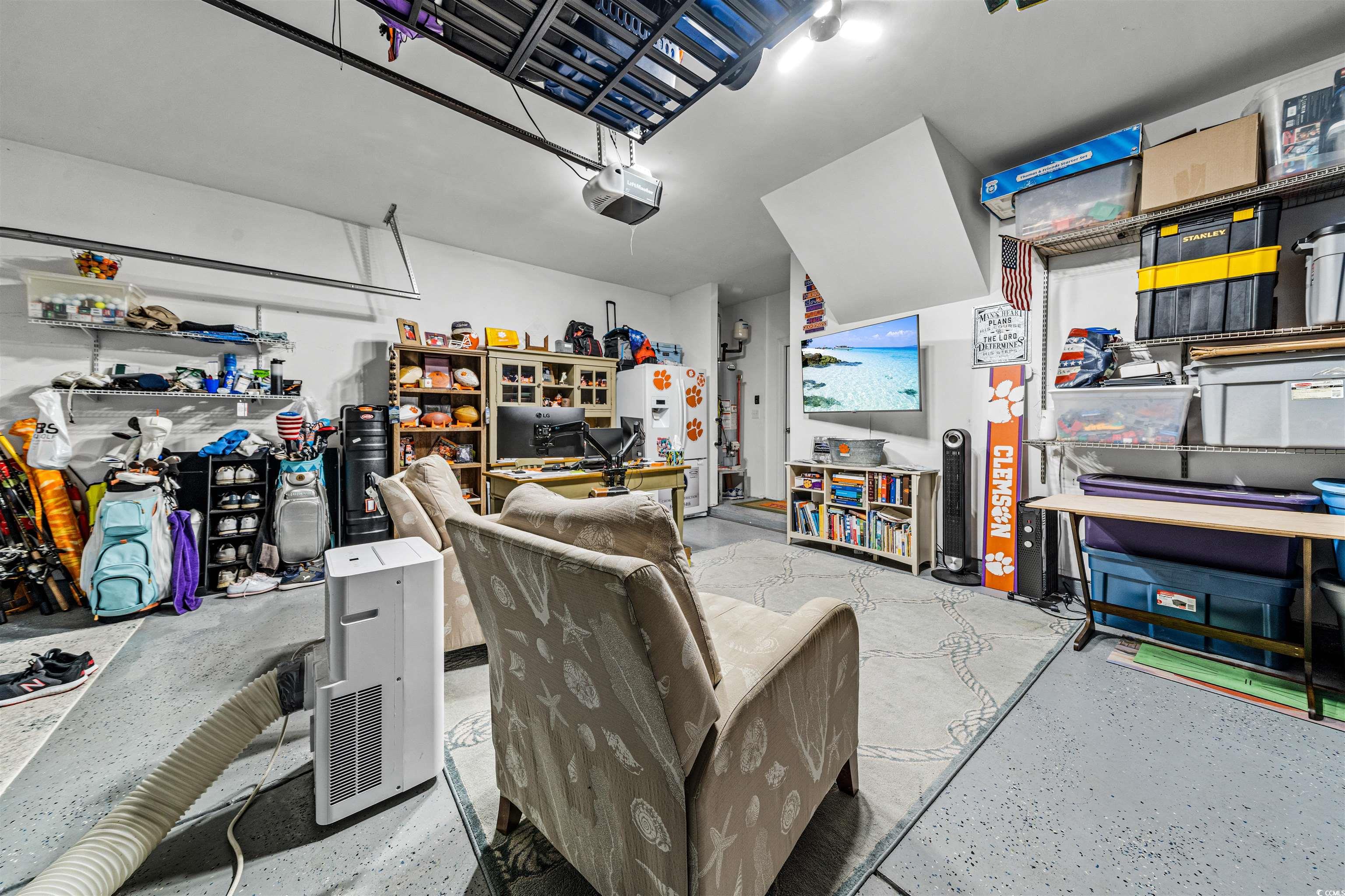 136 Parmelee Drive, Unit C Murrells Inlet, SC 29576 - Photo 29 of 40 Garage with white fridge with ice dispenser, a garage door opener, and gas water heater