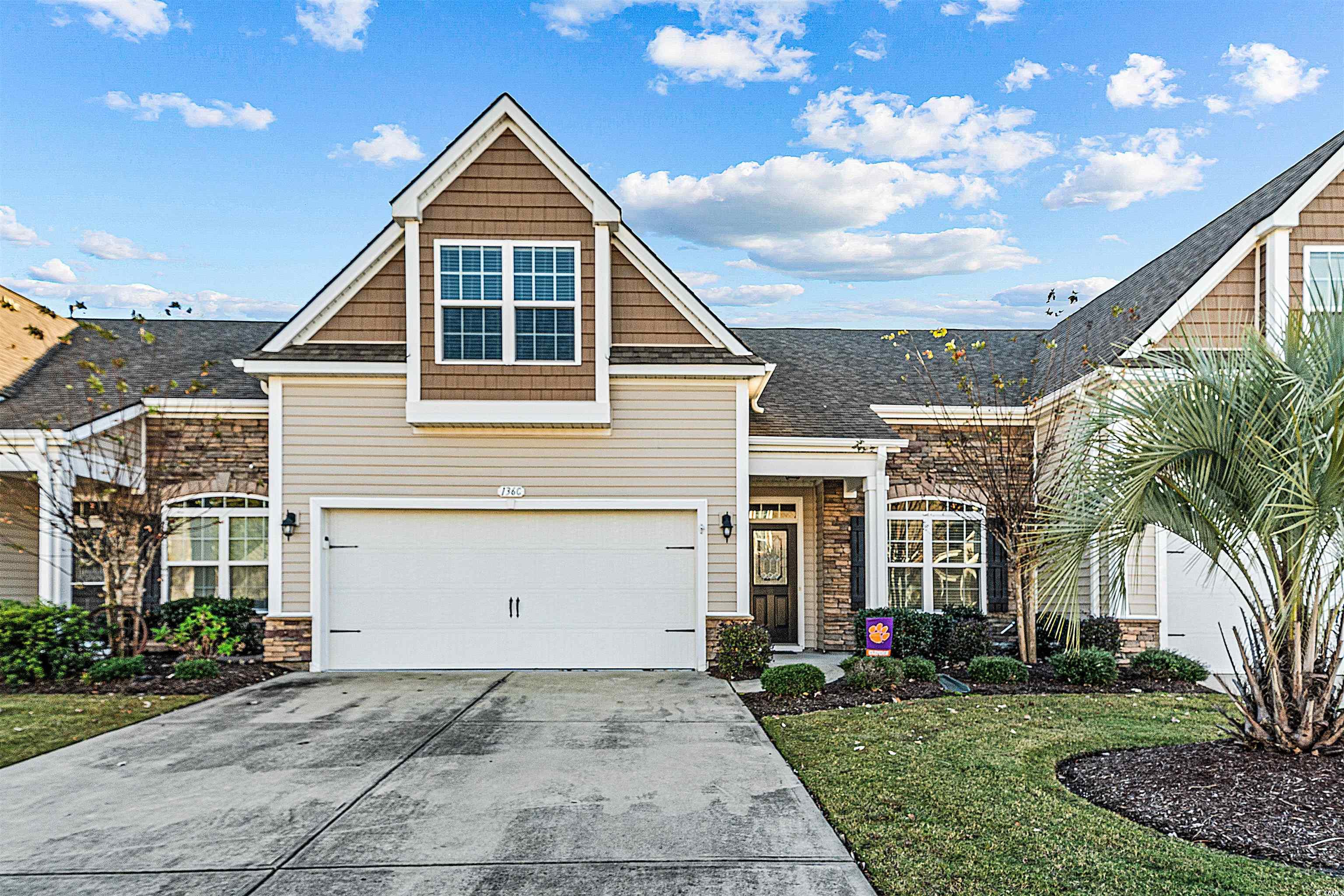 136 Parmelee Drive, Unit C Murrells Inlet, SC 29576 - Photo 31 of 40 Craftsman-style home featuring stone siding, driveway, an attached garage, a shingled roof, and a front lawn