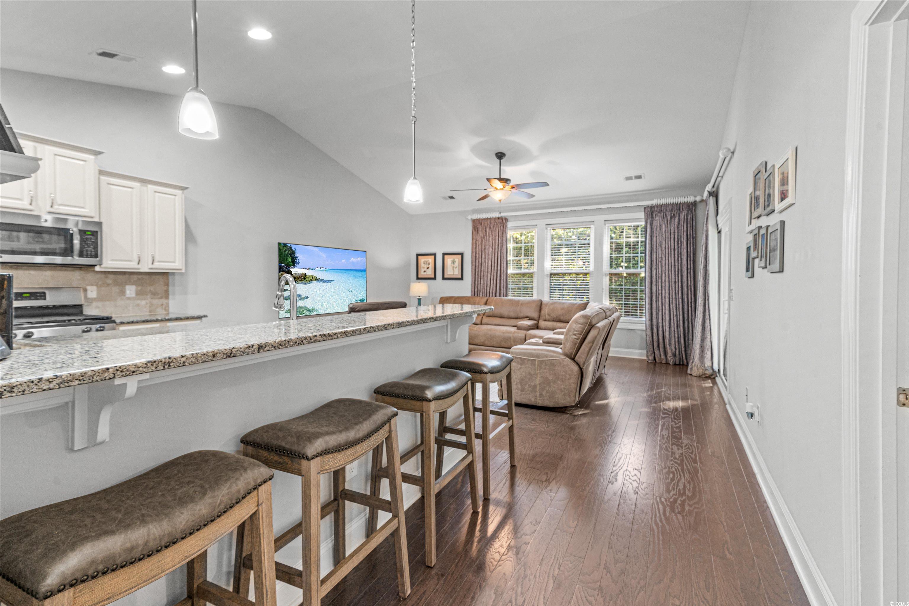 136 Parmelee Drive, Unit C Murrells Inlet, SC 29576 - Photo 10 of 40 Kitchen with light stone counters, hanging light fixtures, dark wood-style floors, appliances with stainless steel finishes, and tasteful backsplash