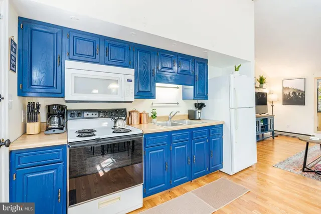 a kitchen with stainless steel appliances granite countertop a stove a refrigerator and a microwave with wooden cabinets