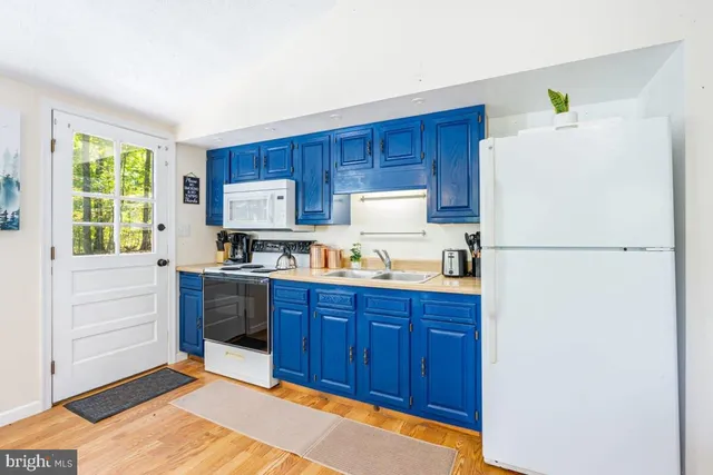 a kitchen with a refrigerator sink stove and cabinets