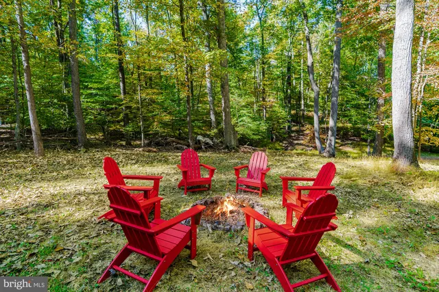 a backyard of a house with fire pit and outdoor seating