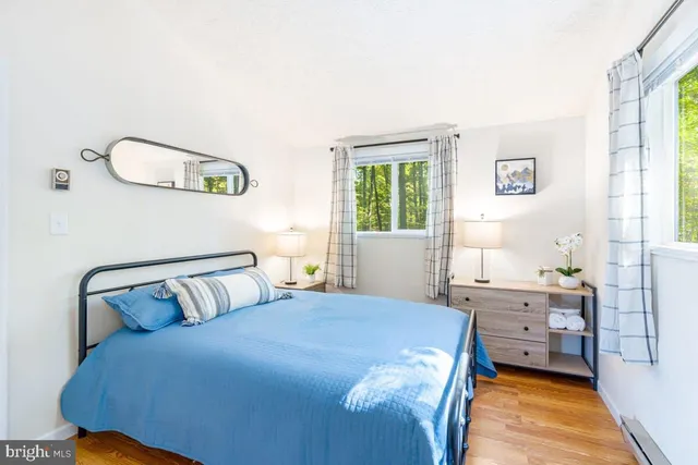 a bedroom with a large bed and wooden floor