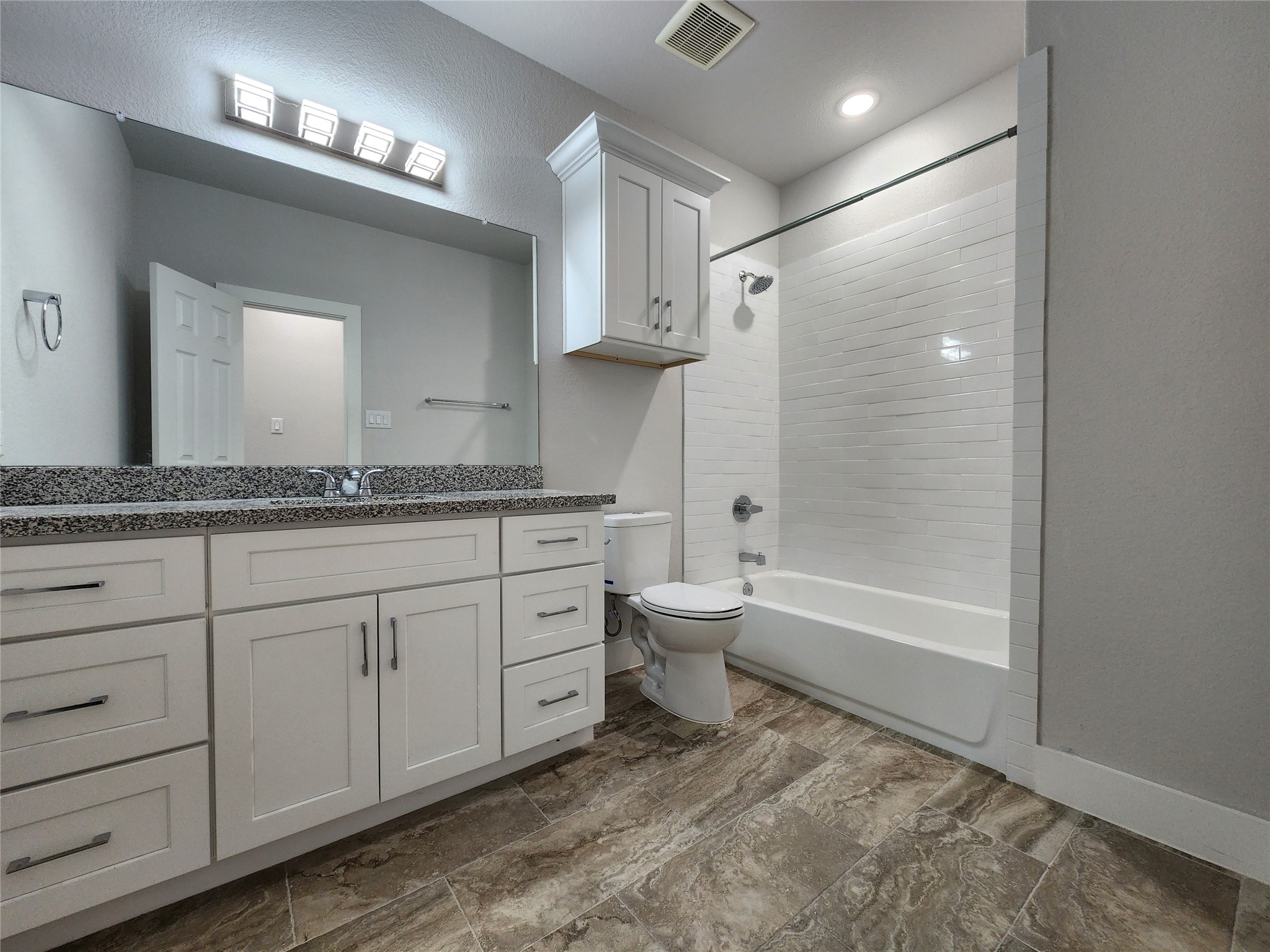 9710 Tuffly Street, Unit B Houston, TX 77029 - Photo 12 of 14 a spacious bathroom with a granite countertop sink a toilet and bathtub