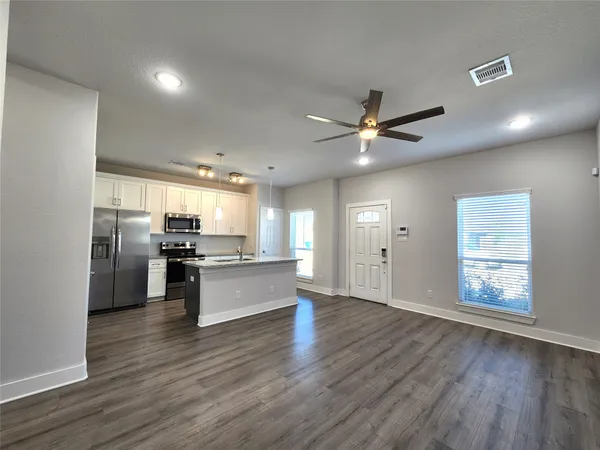 a kitchen with stainless steel appliances kitchen island hardwood floor sink and stove