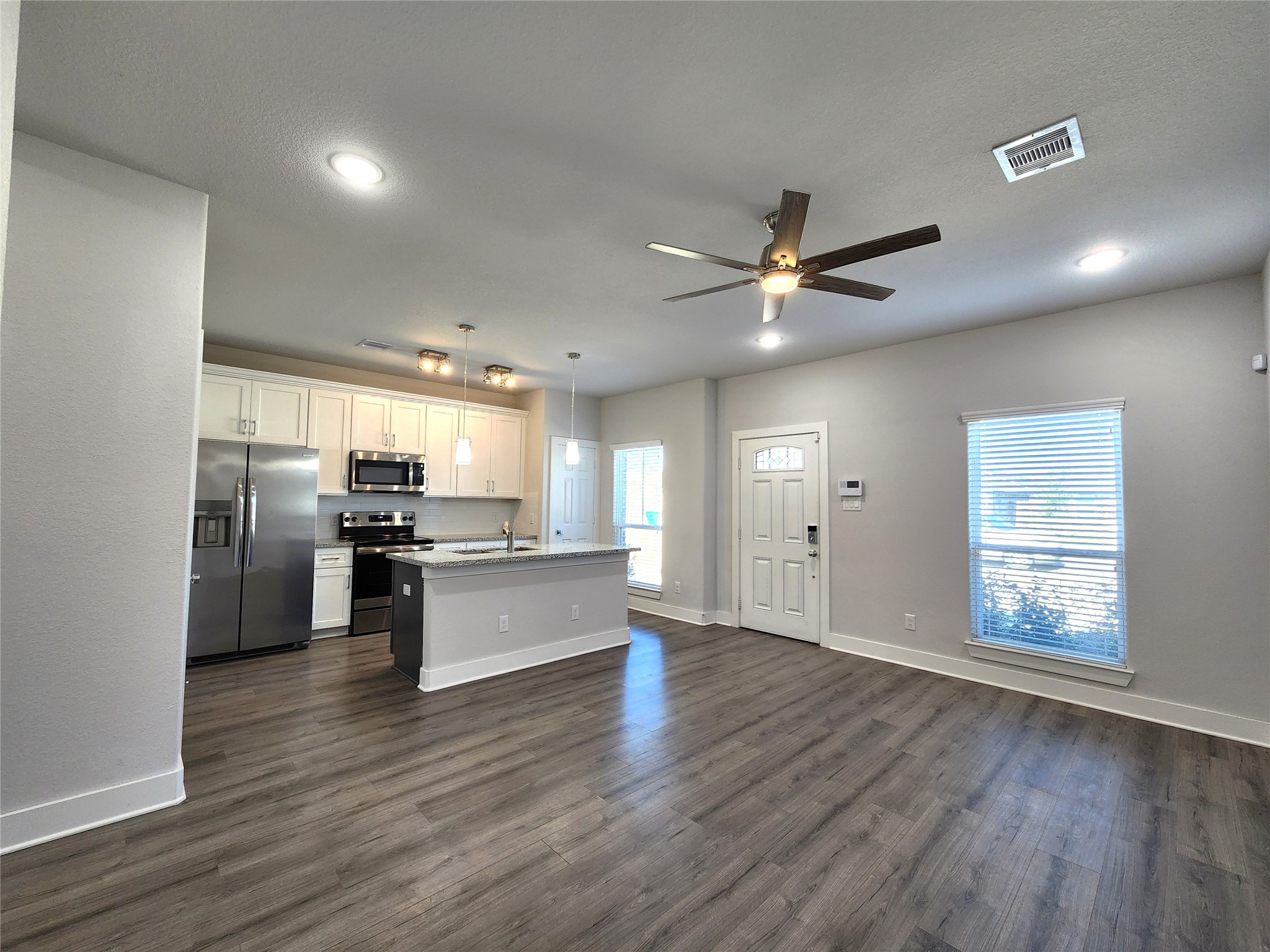 9710 Tuffly Street, Unit B Houston, TX 77029 - Photo 2 of 14 a kitchen with stainless steel appliances kitchen island hardwood floor sink and stove
