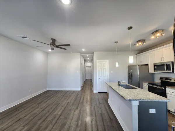 a view of a kitchen with a sink and wooden floor