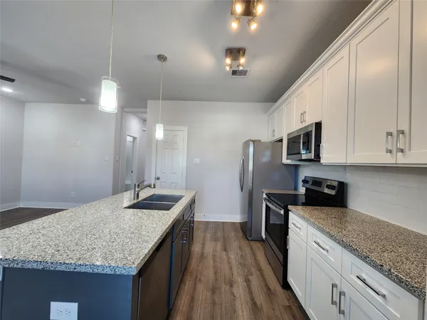 a kitchen with stainless steel appliances granite countertop a sink stove and refrigerator