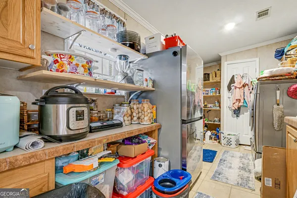 a utility room with fridge dryer and bicycles